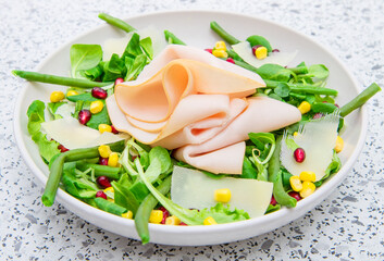 dish with fresh salad and ham slices