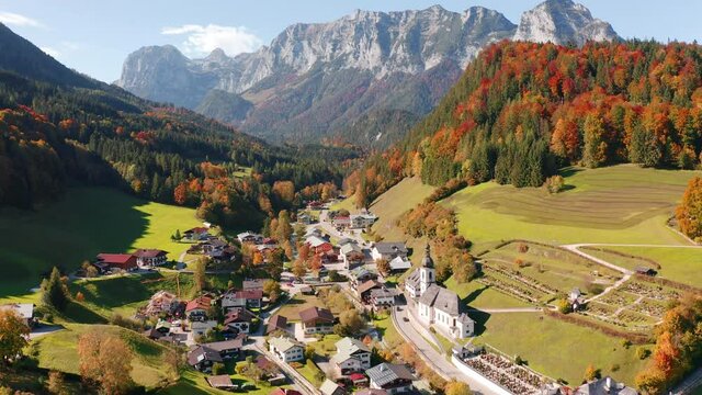 4k drone forward video (Ultra High Definition). Bright morning scene of Parish Church of St. Sebastian. Colorful  autumn view of Bavarian Alps, Ramsau bei Berchtesgaden village, Germany Europe.