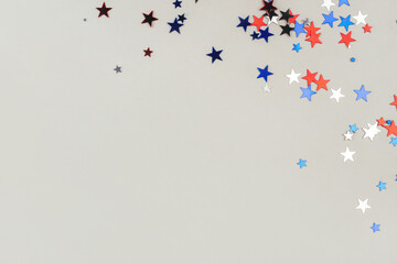 Festive background with confetti in the shape of stars in the color of the American flag. US independence day.