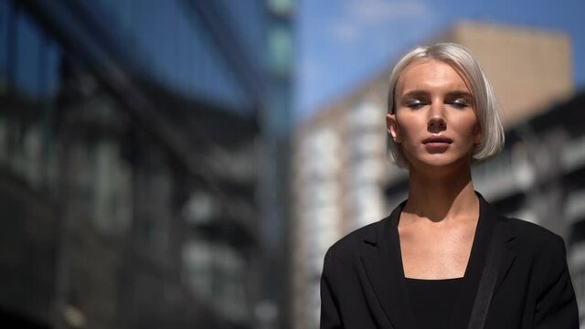 gay man with makeup, walking around the city, glamorous blonde in black clothes