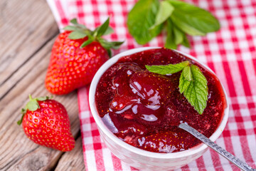Homemade delicious strawberry jam and strawberry on a rustic wooden table