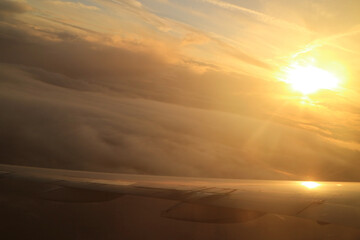Dazzling sun on the cloudscape as seen from the plane window