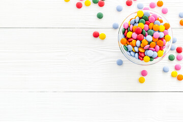 Colorful sweets on white wooden desk from above copy space