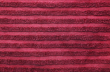 Dark burgundy red cotton terry towel. Soft fabric background of bath towel close up view with loops of thread. Classic simple home decor item for bathroom ans shower