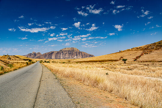 A road in a dry grassland with the Mountain Bishop's hat in Madagascar