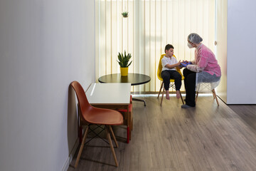 a physical therapist or nurse is talking to and caring for a young child with multiple disabilities in the clinic, rehabilitation center. coronavirus