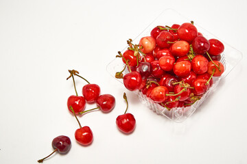 Obraz na płótnie Canvas Container with fresh cherry on a white background.