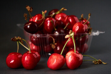 Tray with fresh cherry on a gray background.