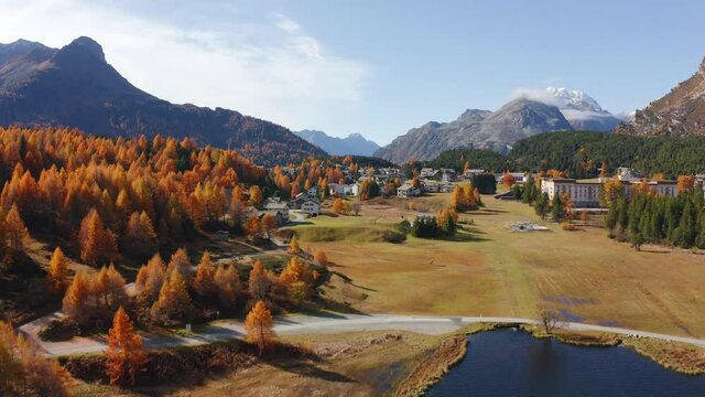 4k drone forward and up video (Ultra High Definition). Sunny autumn view of Sils lake. Nice morning scene of Swiss Alps. Aerial outdoor scene of Maloya village, Switzerland, Europe. 