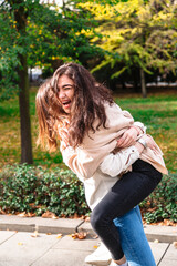 Girl hugs her best friend tightly in park outdoor