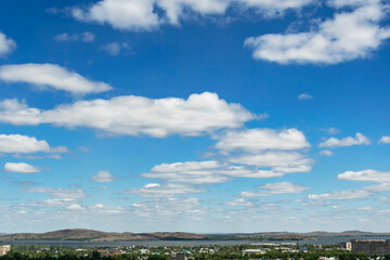 Fototapeta na wymiar White clouds in the blue sky above the city.