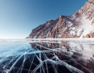 Fotobehang Beautiful crack that goes beyond the horizon on the ice of lake Baikal. © zhuxiaophotography