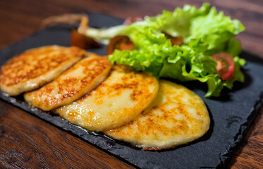 Grilled cheese with vegetables on the plate.