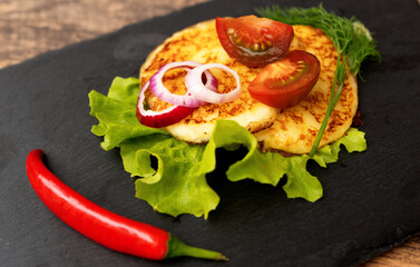 Grilled cheese with vegetables on the plate.