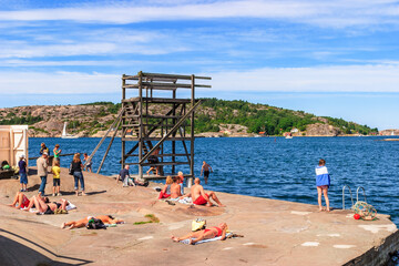 People sunbathing and bathing by the sea