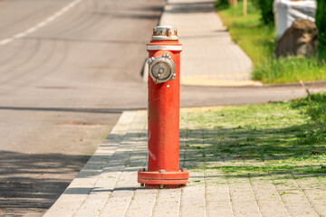 Red fire hydrant standing on the pavement