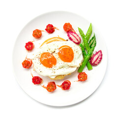 Breakfast with grilled toast on top fried eggs,sprinkle black peppers and salt decorate tomato cherry, asparagus, radish leaf and cucumber carved style top view