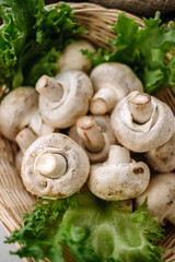 Champignon mushrooms in a basket with herbs on the table. Top view