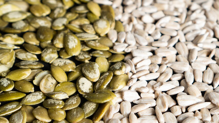 Top view of different seeds as a background. Two parts of sunflower and pumpkin seeds. Healthy food. Seeds texture
