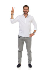 Handsome Elegant Man Is Standing And Showing Peace Hand Sign.