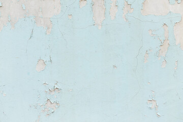 Texture of cracked wall with light blue paint, background or backdrop of abandoned building exterior.