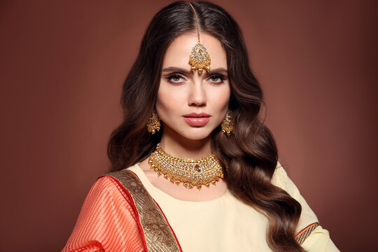 Portrait of beautiful indian girl in saree. Young hindu woman model with kundan golden jewelry set. Traditional Indian costume lehenga choli.