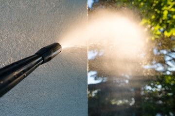 power washing the wall - cleaning the facade of the house - focus on the tip of the spray nozzle- shallow depth of field - 356649717