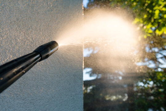 power washing the wall - cleaning the facade of the house - focus on the tip of the spray nozzle- shallow depth of field