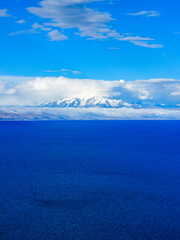Lake Ticticaca on a sunny day with blue skies and clouds at the horizon