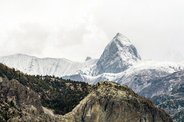 Steep mountain peak covered in snow,  Annapurna Circuit trail, Nepal