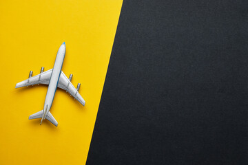 Toy airplane on yellow and black background with copy space.