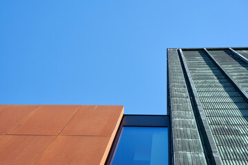 Building with rusty wall against a blue sky. Copy space.