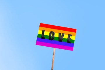 Gay pride concept. Holding a banner with the lesbian, gay, bisexual and transgender LGBT rainbow flag.