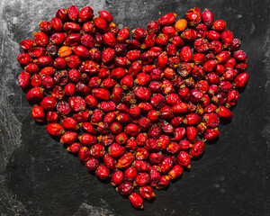 heart made of rose hips on a baking sheet metal background. heart of red rosehip berries.