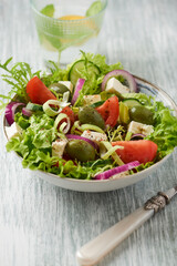 Salad with Green Olives, Tomatoes, Endive, Cucumber and Feta Cheese. Wooden background. 