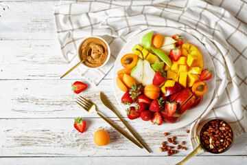Naklejka na ściany i meble Fruit platter on a wooden background, top view