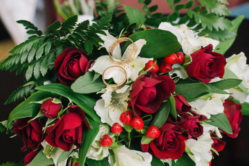 Wedding rings on a bouquet of burgundy roses
