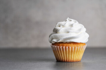 Birthday cream cupcake on a gray background.