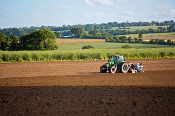 Fototapeta premium Tracteur en campagne qui laboure la terre en été.