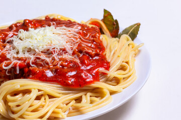 Delicious Spaguetti Pasta with bolognesa tomato sauce and chopped meat. Adorned with cheese and Laurel leaf