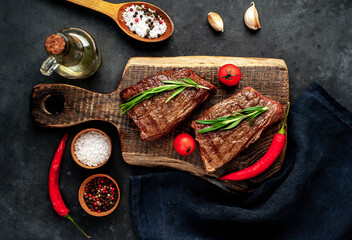 Grilled beef steak with spices on a stone background