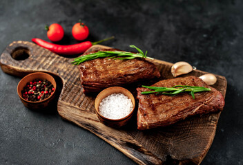 Grilled beef steak with spices on a stone background