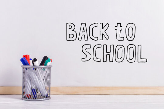 White board, markers in the stand on the table. The inscription marker on a white board, Back to School. - Powered by Adobe