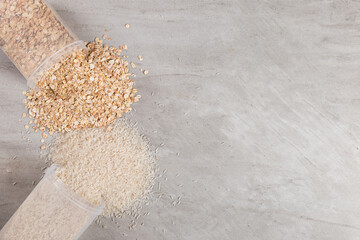 Cans of rice and oatmeal are scattered on the table. Useful complex carbohydrates, proper nutrition.