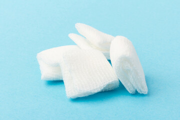White gauze pads on  blue background. Materials for dental surgery. Close up