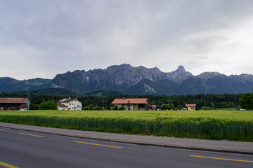 view of the road and houses by the alpine mountains in Switzerland