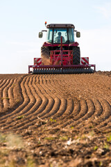 Obraz premium Tracteur labourant un champ pour semer du maïs.