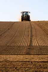 Paysage agricole et tracteur en campagne en train de labourer son champ.