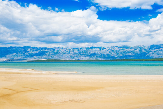 Beautiful sand lagoon near town of Nin in Dalmatia, Croatia. Adriatic coastline and blue sky with clouds. Velebit mountain in background.