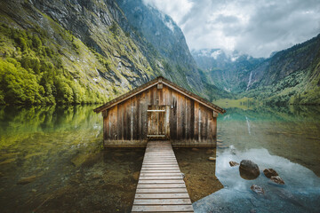 Fototapeta na wymiar Wooden boat house at the shores of an alpine lake in the mountains